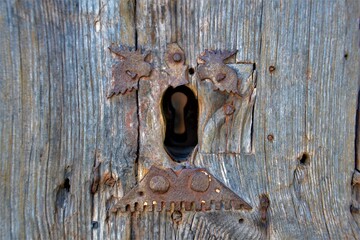 Iron keyhole in a historical wooden old door in Europe