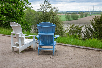 Zwei Liegestühle auf einer Terrasse mit Blick auf Wiesen und Felder