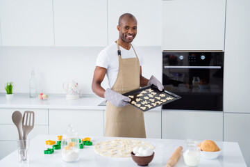 Portrait of his he nice attractive cheerful guy baking handmade snack pie cake special recipe tasty yummy snack cozy comfort homey in modern light white interior house kitchen