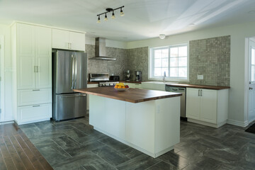 New grey and white kitchen with marble tiles, appliances and timber bench tops