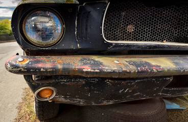 Round headlight of an abandoned classic car