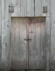 Old barn doors with a lock made from rustic weathered wood.