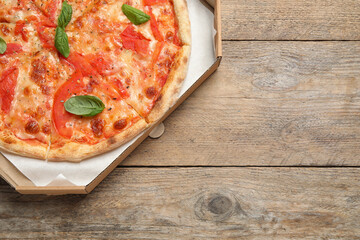 Delicious pizza Margherita on wooden table, top view. Space for text
