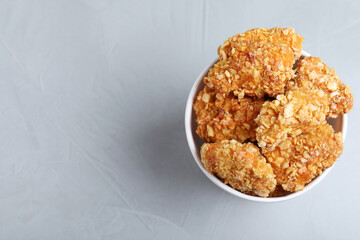 Bucket with yummy nuggets on light background, top view. Space for text