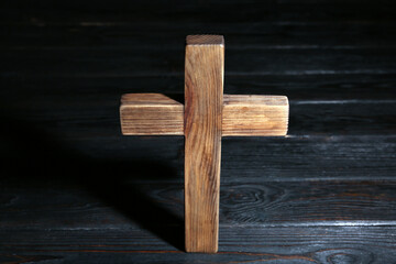 Christian cross on wooden table, above view. Religion concept