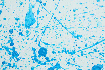 Blue paint splashes on white canvas as background. Art and creativity