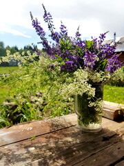 Bouquet of wildflowers on a rustic table at country cottage.