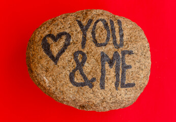 the english  writing you and me with a heart drawn on a stone /the writing you and me with a heart drawn on a stone,indicates the love promise of two lovers