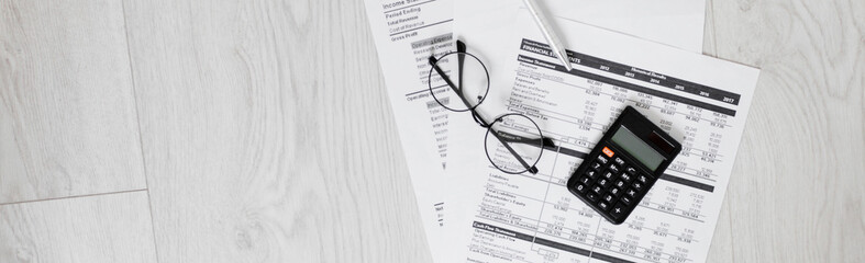 Office desk with supplies calculator pen notepad keyboard and chart ,glasses.selective focus,vintage color