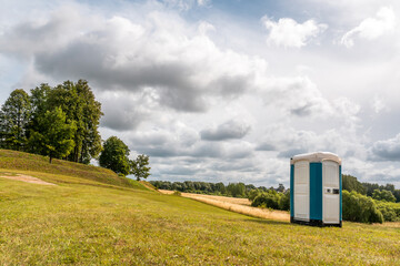 Portable plastic toilet on grass field