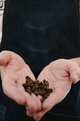 barista irreconocible enseñando granos de café en la mano