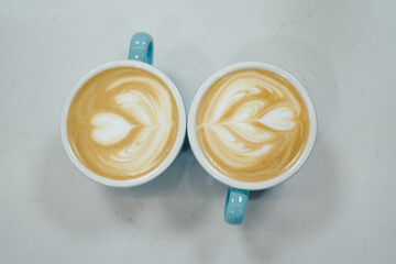 dos tazas de café con leche con dibujo