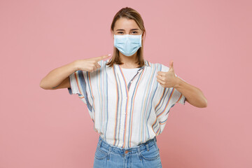 Young blonde girl in striped shirt isolated on pink background. Epidemic pandemic coronavirus...