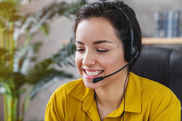 Portrait of cheerful girl operator manager talking on hot help line providing support service...