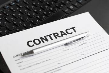 Business Contract and pen close up on laptop background