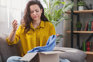 Unhappy young mixed race girl with cardboard box dissatisfied with wrong item delivery