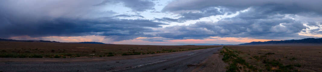Panoramic landscape of Kazakhstan steppe in evening time with rain clouds. Clouds background....