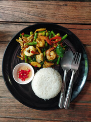 Stir fried seafood with steamed rice in black plate