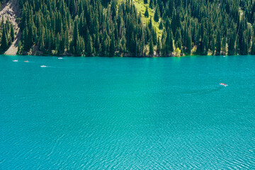 Beautiful view to Kolsai or Saty lake with mountains background. Summer vacation concept. Scenic travel background. Travel in Kazakhstan concept.