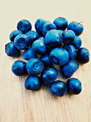Blueberry (Vaccinium myrtillus). Blueberry fruit on a wooden board, forest fruit.