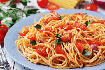 A plate with spaghetti with tomatoes	