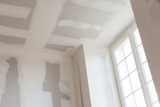 unfinished plasterboard, during reconstruction, closeup wall and ceiling