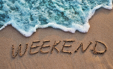 The word weekend written on sand. Sunset beach. Summer background. - obrazy, fototapety, plakaty