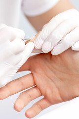 Obraz na płótnie Canvas Manicure master uses an electric nail machine to remove nail polish hands in nail salon