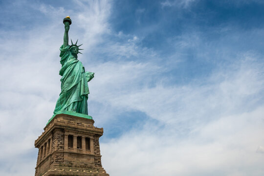 Statue of Liberty on Liberty Island closeup with blue sky in New York City Manhattan - Image