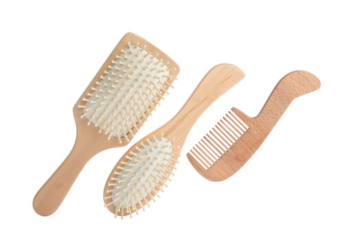 Different wooden hair brush and comb on white background, top view
