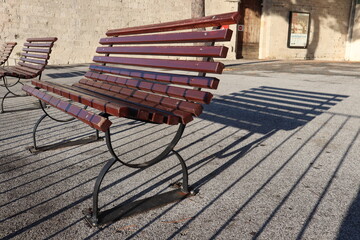 A row of wooden benches with shadows