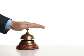 Man ringing hotel service bell at wooden table