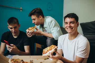 teenagers having fun eating pizza at home