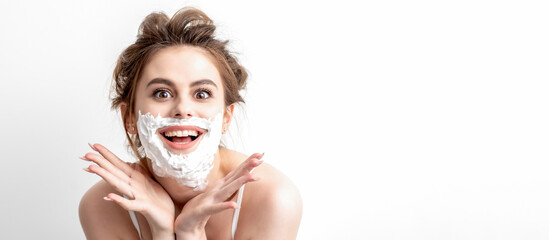 Beautiful young caucasian woman with shaving foam on her face posing on white background