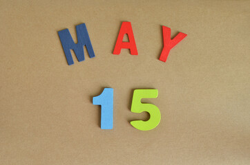 May 15, Toy alphabet with a brown background.