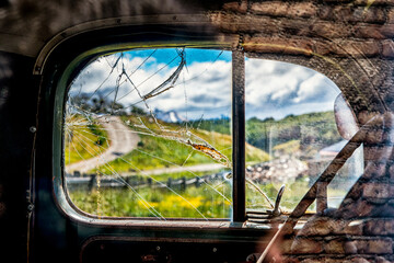 Old car  view of Tierra del Fuego through broken window in Argentina