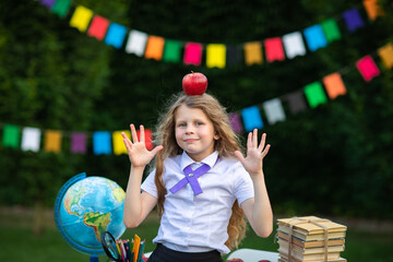 Young girl posing with red Newton apple against flags background. Back to school.