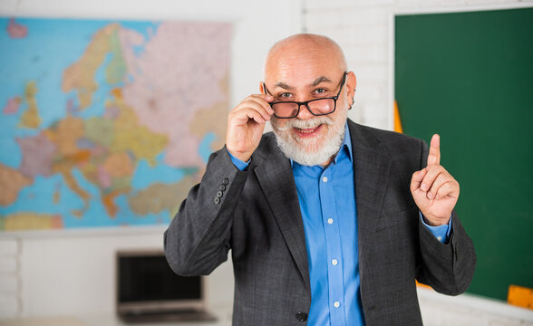 idea and inspiration. become good at geography. senior man teacher at blackboard. bearded tutor in glasses near geography map. back to school. lesson in classroom. learn geography easily