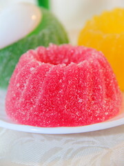 Red marmalade in the shape of a pudding is on the table close-up. Sweet confectionery products.