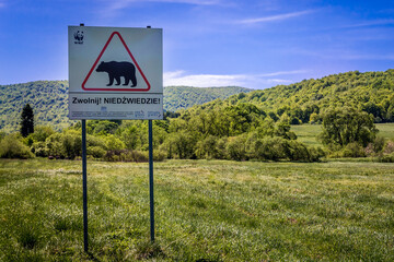 Warning sign with Slow down, bears inscription on a road in Ustrzyki Gorne, Bieszczady Mountains, Poland