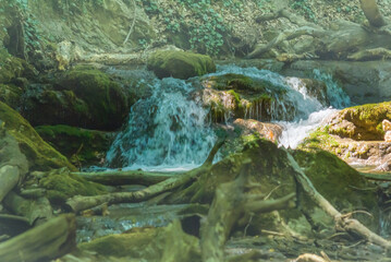 closeup rushing mountain river with small waterfall