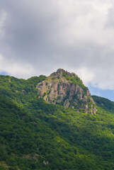 Naklejka premium green mountain valley with high alone mount peak