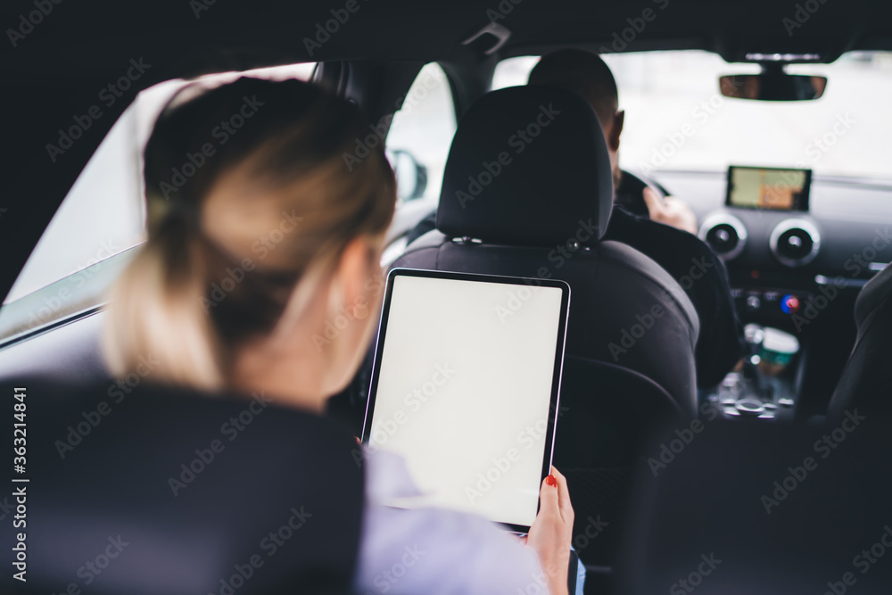 Aufkleber back view of female sitting on backseat and using modern touch pad with blank screen for advertising