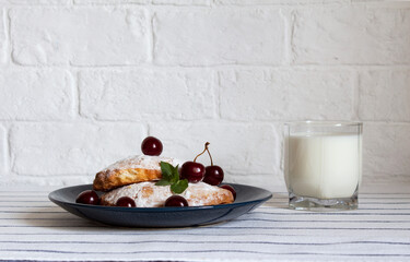 Dessert with a cherry. Russian pastries. A glass of milk.