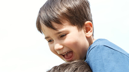 Boy sitting on the neck of his father.