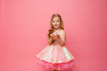 little girl with birthday cake on pink background