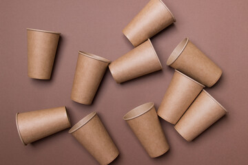 group of brown cardboard eco-friendly cups on brown background. top view. close-up