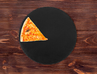 A slice of tasty margherita pizza with mozzarella, bocconcini and basil leaves on slate round...
