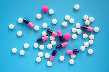 Flat lay of pills and tablets on blue background 