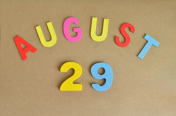 August 29, Toy alphabet with a brown background.